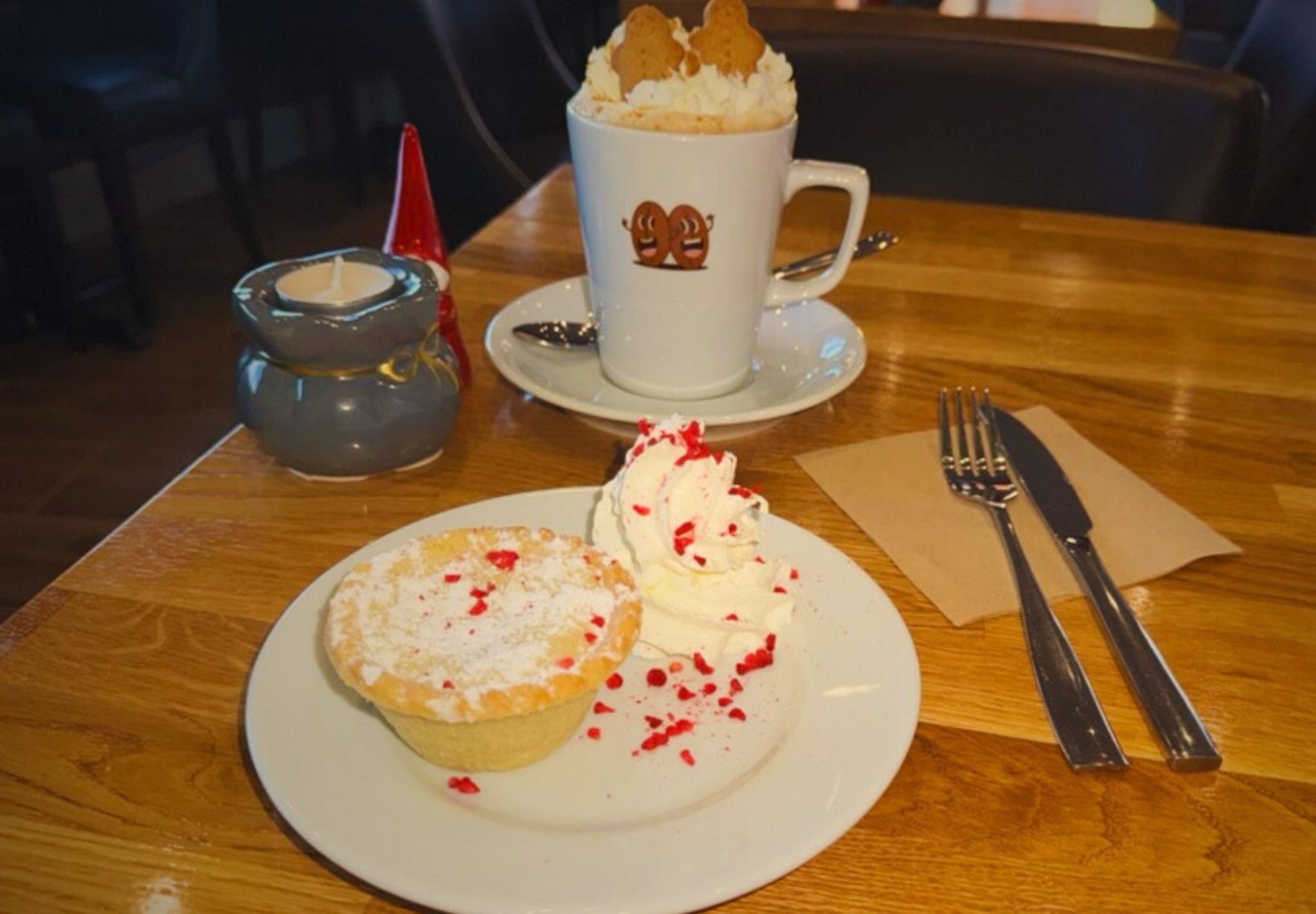 Cake and a branded hot chocolate on an oak cafe table