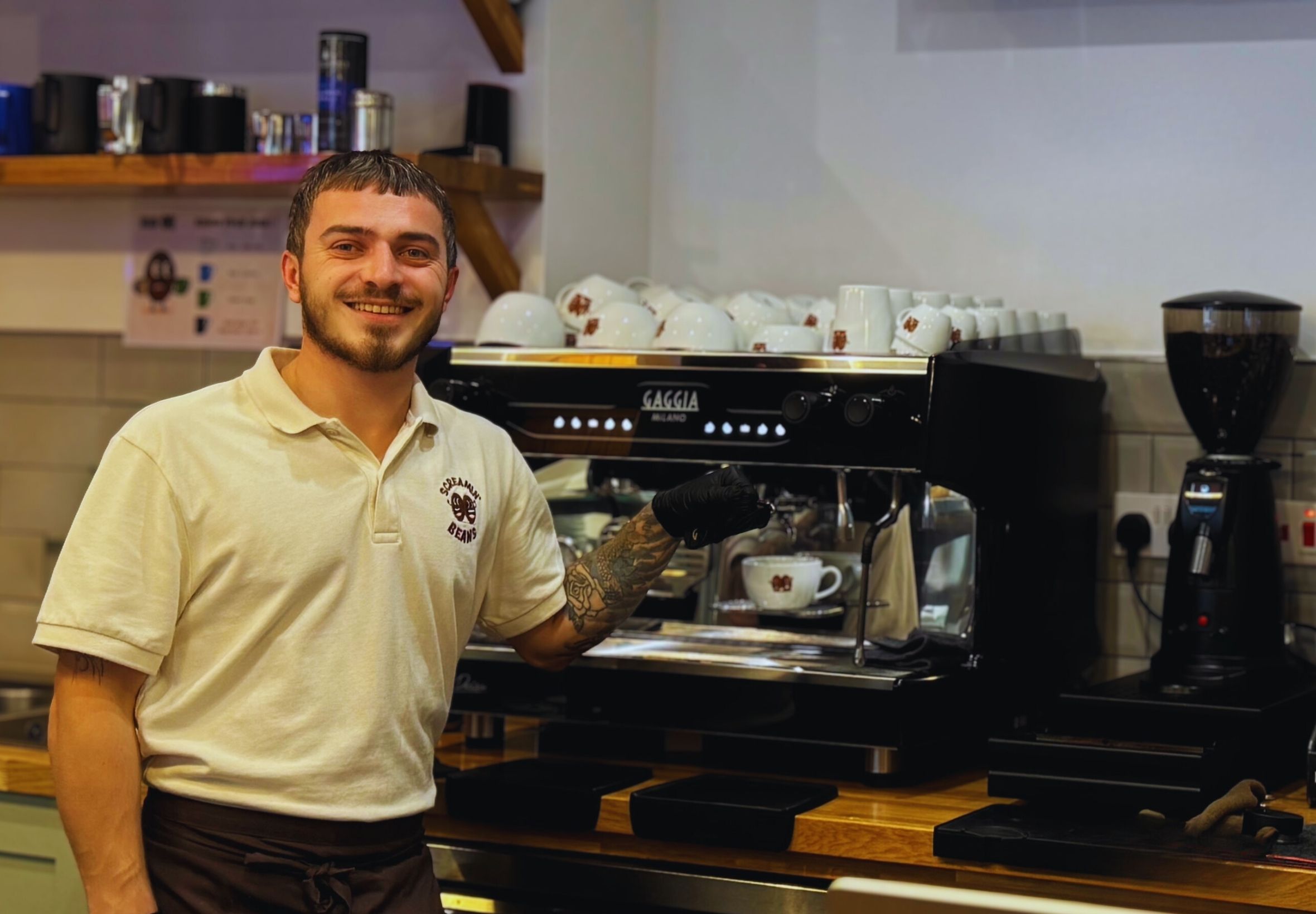Emi, chief barista at Screamin' Beans, beside the coffee machine